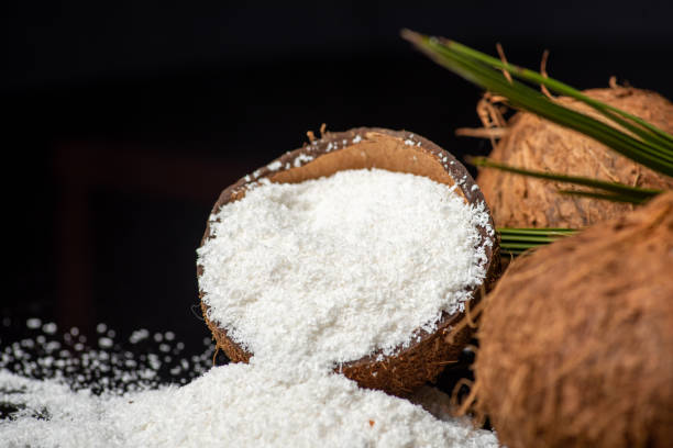 istock Grated coconut powder falling out of a coconut shell with copy space 1307916288