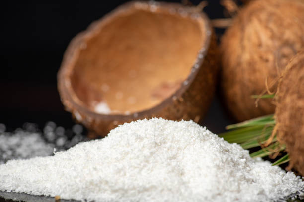 istock Grated coconut powder falling out of a coconut shell with copy space 1307917000