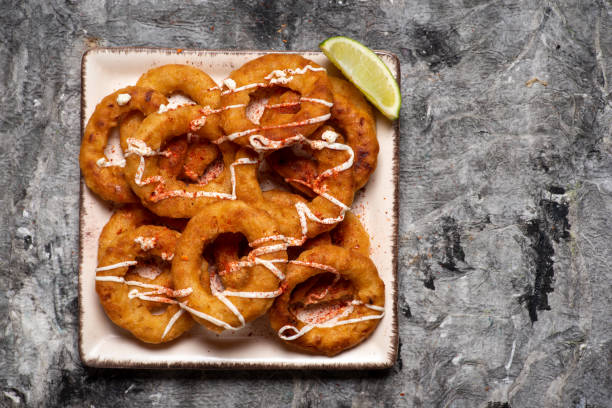 Crispy fried onion rings with cheese snacks Crispy fried onion rings snacks with cheese sauce tabletop view fried onion rings stock pictures, royalty-free photos & images