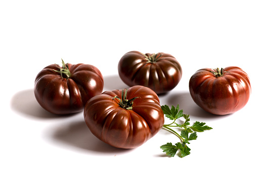 Fresh dark red raw tomato called primora isolated on white background