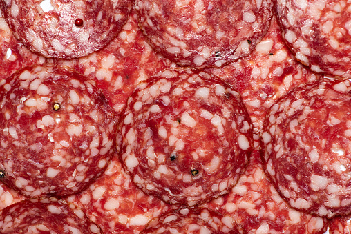Pepperoni or salami industry produced processed meat and fat mixture making a background pattern top view