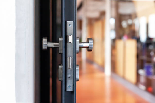 Open unlocked doors in an empty secure vacant corporate business area, nobody, door knob lock side closeup. Door left open, office building security abstract concept. Simple entrance and a hallway abra las puertas abiertas en una zona de negocios corporativa vacía y vacía, nadie, cierre de la cerradura de la perilla de la puerta. puerta abierta, concepto abstracto de seguridad del edificio de oficinas. entrada sencilla y un pasillo