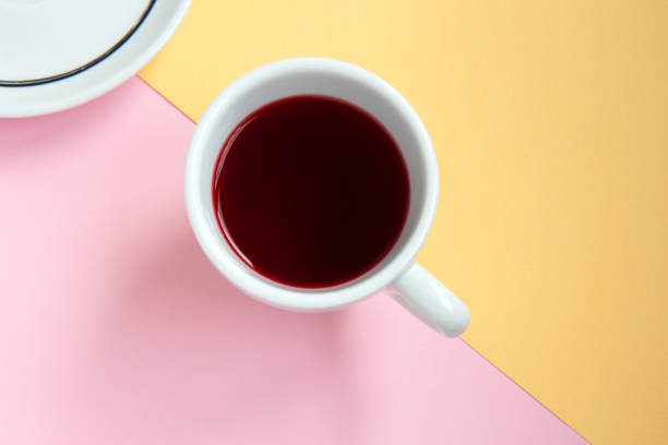 istock Hibiscus red tea in a white cup on pink and orange background 1307925880