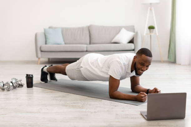istock African Guy Exercising At Laptop Standing In Plank At Home 1307927965