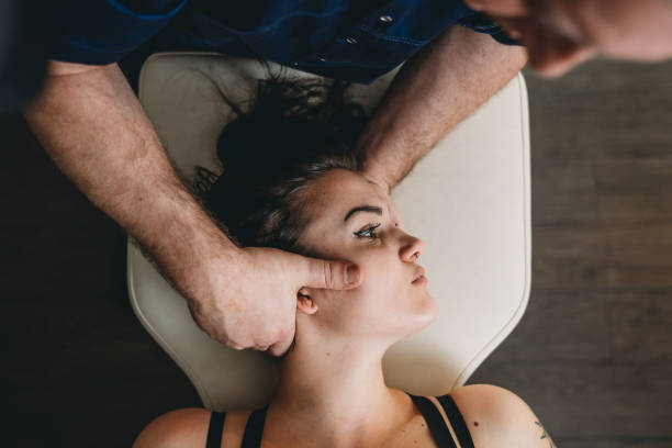 trattamento osteopatico su una giovane donna - osteopath chiropractic adjustment skull massaging foto e immagini stock