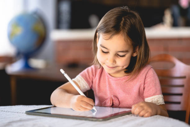 istock Little Child Girl Drawing On Digital Tablet Using Digitized Pen 1307929085