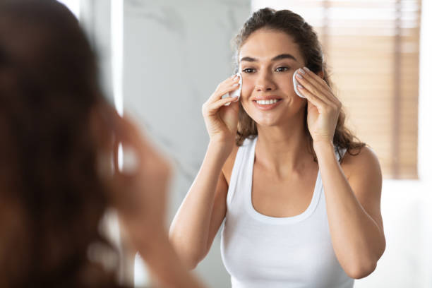 istock Young Lady Using Cotton Pads Cleaning Skin Standing In Bathroom 1307929264