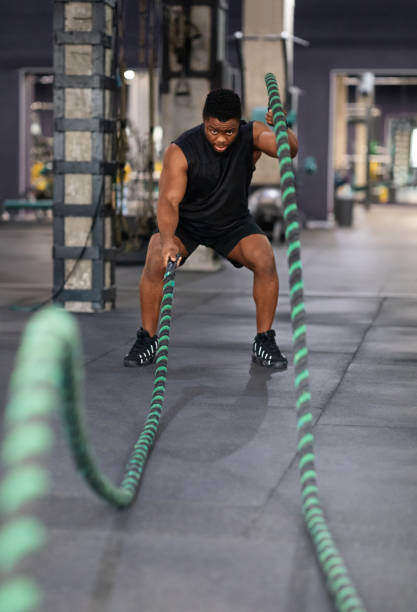 istock Muscular black guy having work out with ropes at gym 1307930331