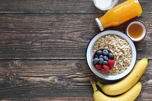 Healthy breakfast with Muesli cereal mix,orange juice, banana and fresh berries .Close up, copy space