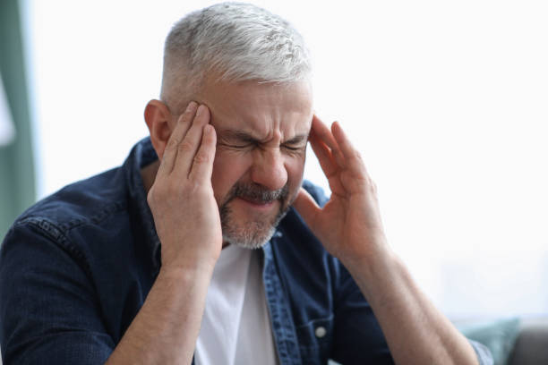 istock Closeup of mature grey-haired man suffering from headache 1307931839