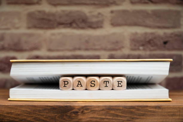 istock Paste word written on wooden blocks between book pages on a shelf. 1307932132