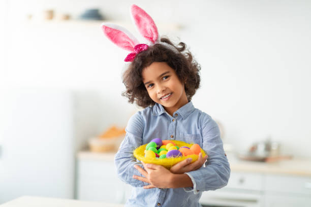 istock Black girl wearing bunny ears on Easter day, holding eggs 1307932822
