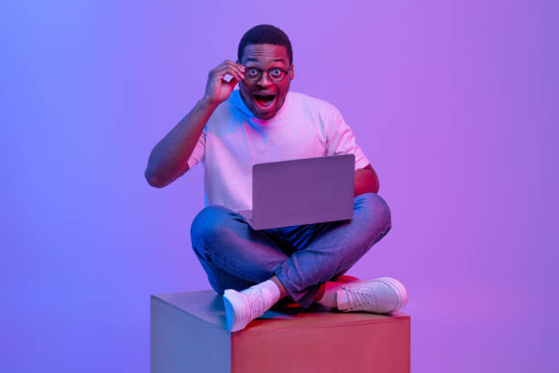 istock Amazed Black Guy Sitting With Laptop, Looking At Camera With Opened Mouth 1307932842