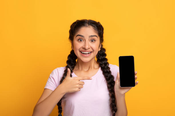 istock Surprised Indian woman pointing at blank smartphone screen 1307932905