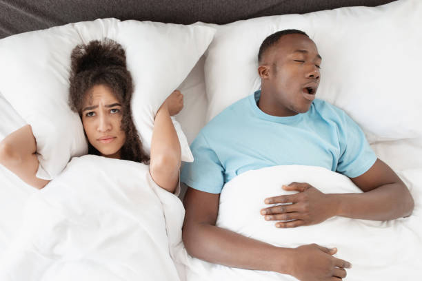 roncando hombre durmiendo con apnea y mujer sin dormir, esposa enojada incapaz de dormir - couple love snoring sleeping fotografías e imágenes de stock