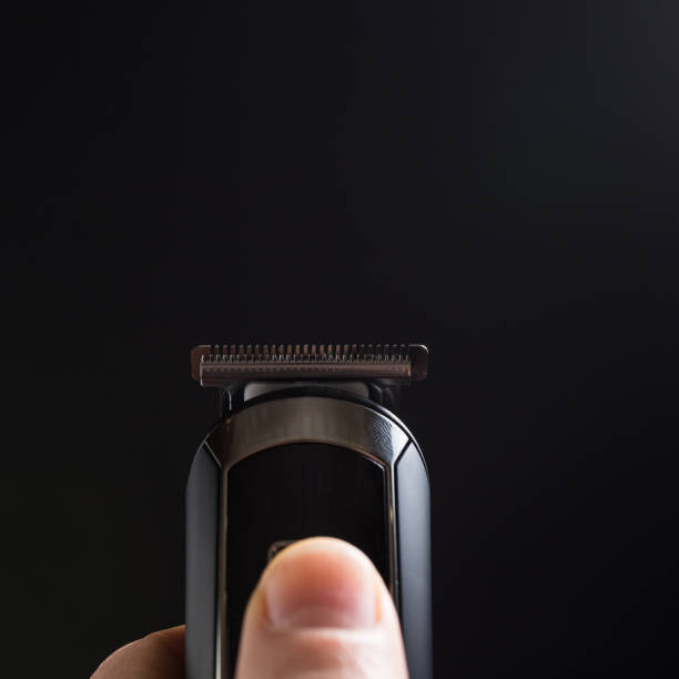 istock Razer in hand close up. Shaving machine on black background 1307933117