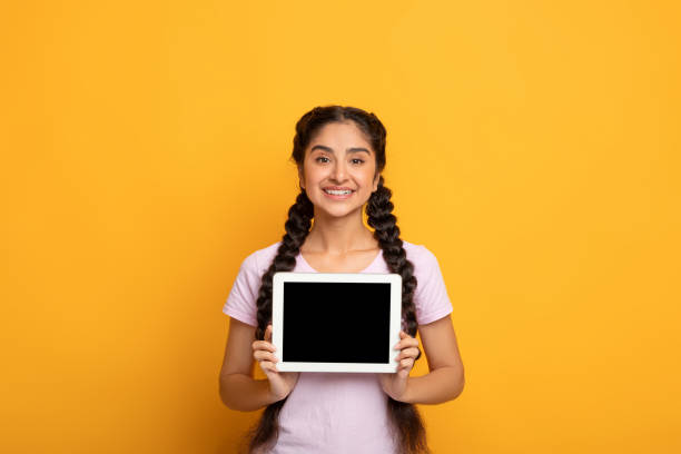 istock Smiling Indian woman showing blank tablet screen 1307933502