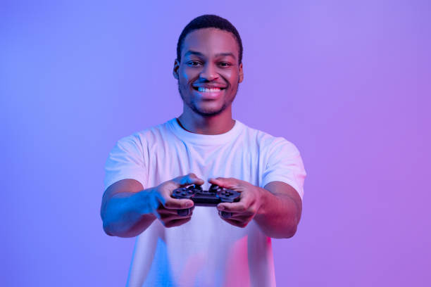 istock Modern Entertainment. Smiling Black Guy In Neon Light With Joystick In Hands 1307933519