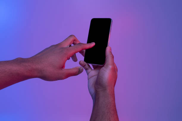 istock Hands Using Smartphone With Black Screen In Neon Light Over Purple Background 1307933646