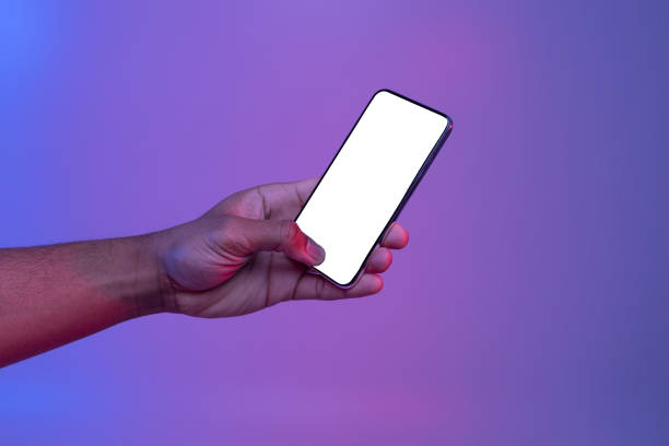 istock Black Male Hand Holding Smartphone With Glowing White Screen Under Neon Light 1307933670