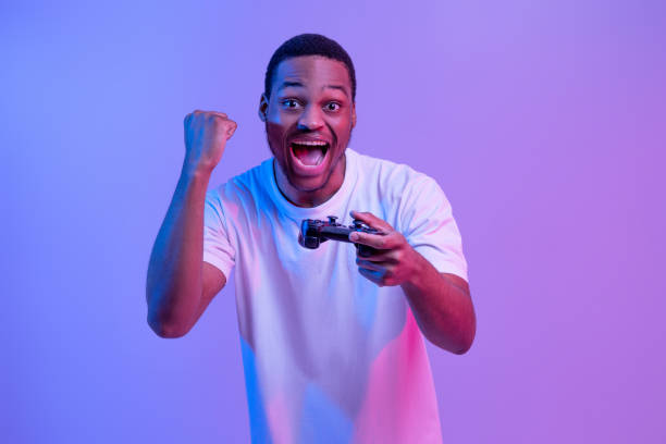 istock Overjoyed Black Man With Joystick In Hand Celebrating Win In Video Game 1307934241