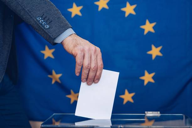 istock Man putting a ballot into a voting box - European Union. 1307934462