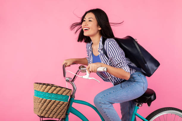istock Asian lady riding retro bicycle with wicker basket at studio 1307935042