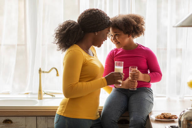 istock Loving Black Family Mother And Daughter Bonding While Having Snacks In Kitchen 1307935103