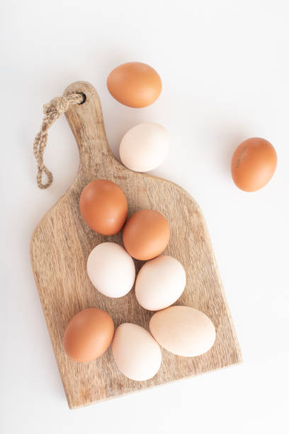 istock white and brown eggs lie on a wooden board on a white table. home life. The process of preparing for Easter. 1307936269