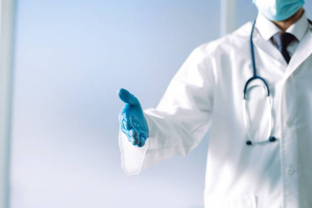 istock doctor with a stethoscope holding out his hand for a handshake 1307936924