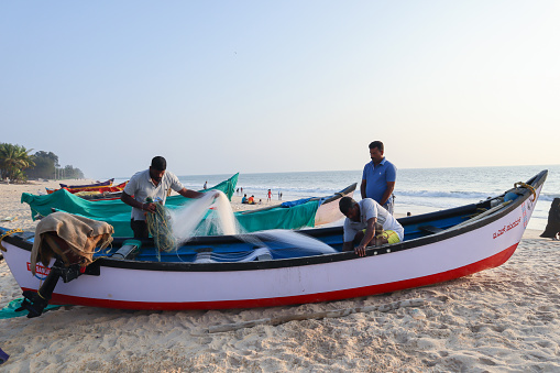 Fishermen and their boat at the Shore, Sea Fishing is main Occupation and Livelihood for the Natives  settled along the Padubidre beach in Coastal Karnataka.