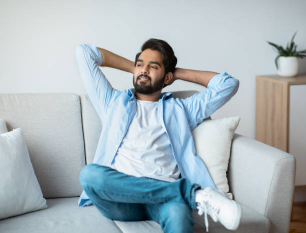 istock Domestic Rest. Arab Man Leaning Back On Sofa With Hands Behind Head 1307938435