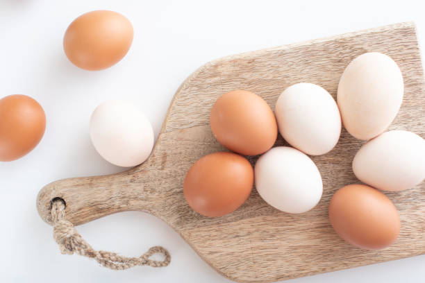 istock white and brown eggs lie on a wooden board on a white table. home life. The process of preparing for Easter. 1307938521