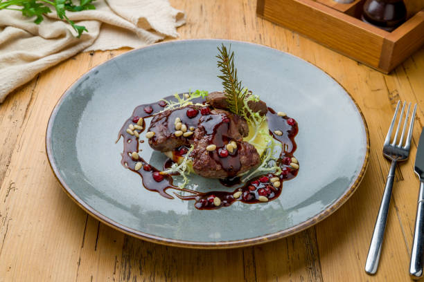 istock fried deer fillet with berry sauce on grey plate on wooden table 1307938892
