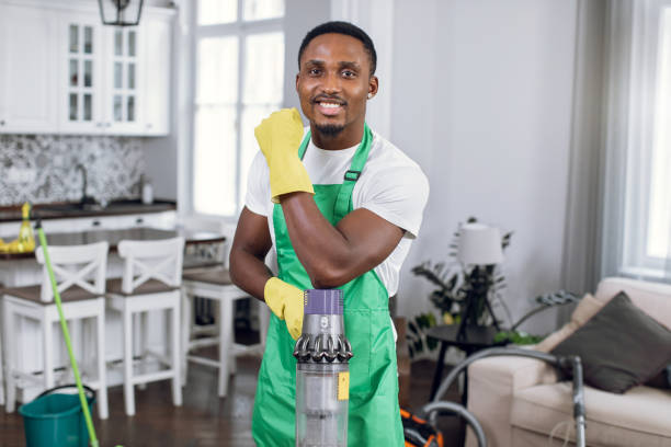 istock Smiling afro american man posing with vacuum cleaner 1307939065