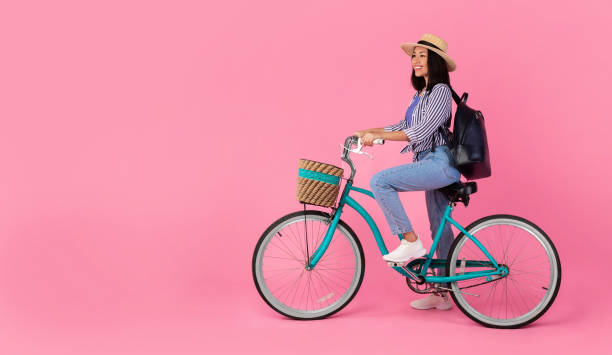 istock Asian lady riding retro bicycle with wicker basket 1307939134