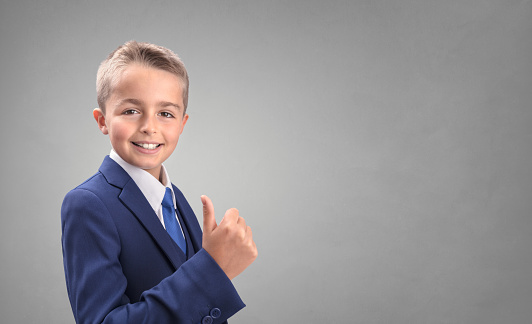 Young businessman boy in suit with thumbs up agreeing and giving his approval with copy space