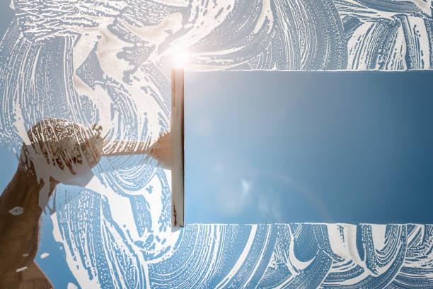 limpiador de ventanas usando un chirrido para lavar una ventana - cristalino fotografías e imágenes de stock