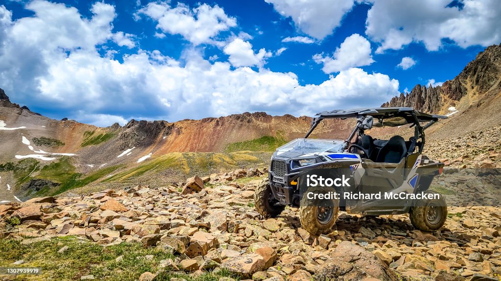 4x4 Side-by-Side off-road vehicle, UTV ATV with a beautiful mountain range in the background near Ouray, Colorado. Yankee Boy Basin. Rocky Mountains. Off-Road Vehicle Stock Photo