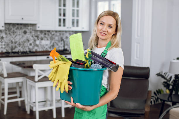 istock Pleasant woman holding bucket with cleaning tools 1307940037