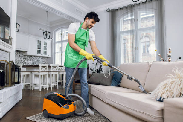 istock Indian man using vacuum cleaner for cleaning couch 1307940144