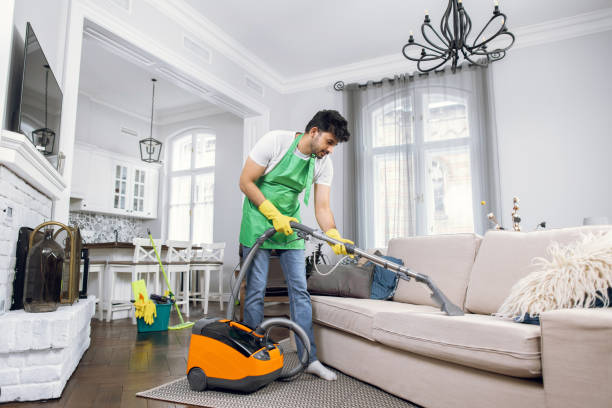 istock Indian male cleaner cleaning sofa with modern vacuum cleaner 1307940192