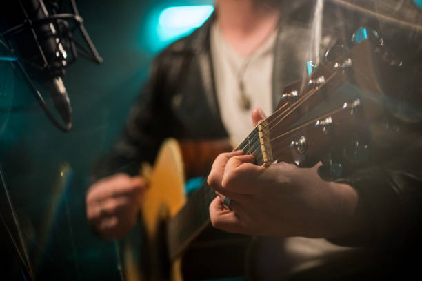 istock Male musician playing guitar in recording studio 1307941717