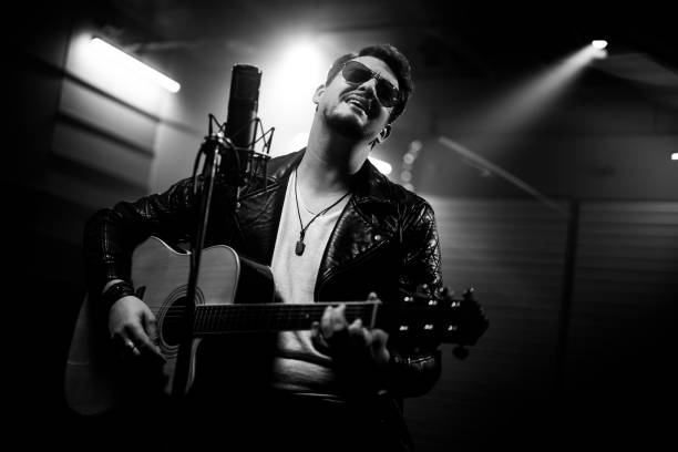 istock Rocker playing acoustic guitar and singing in recording studio 1307941719
