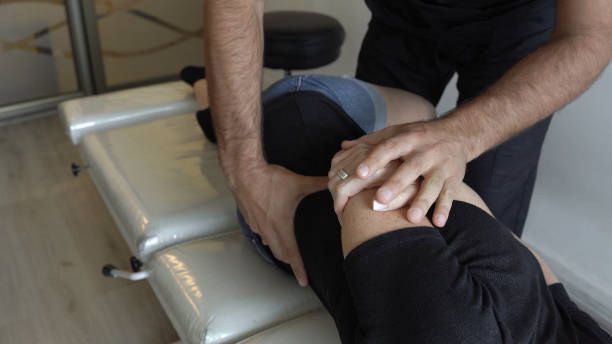 mani di chiropratico che lavorano su paziente donna in barella - chiropractor human spine office physical injury foto e immagini stock