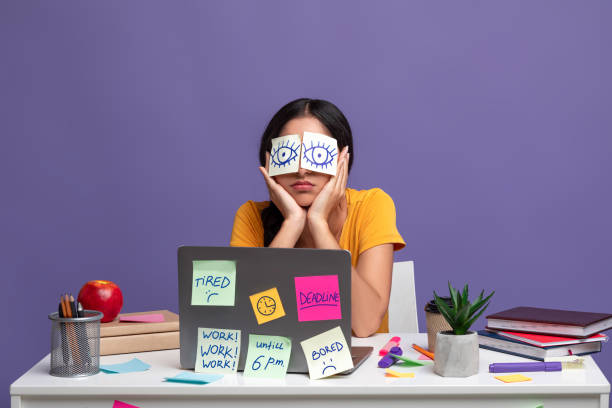 istock Tired woman sitting at desk with sticky notes 1307942122