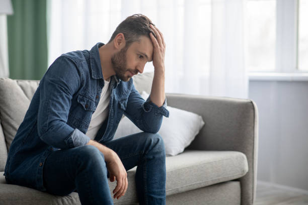 istock Frustrated middle-aged man sitting on couch in living room 1307942759