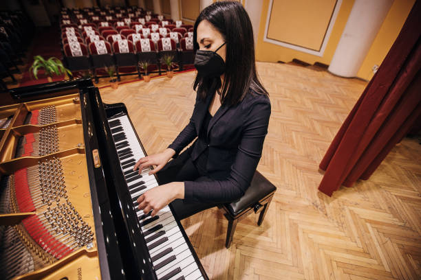 istock Female playing piano at concert hall 1307943338