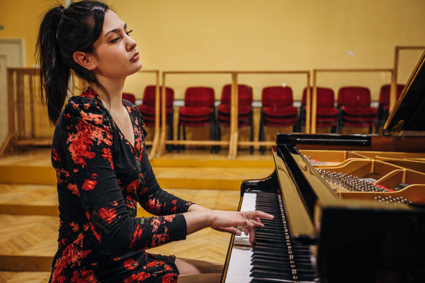istock Female playing piano at concert hall 1307943394