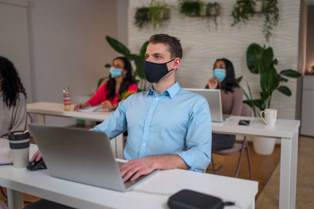 istock White collar worker with protective face mask working on a laptop 1307944286